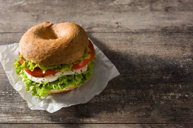 Sebzeli sandviç, domates, marul ve ahşap masada mozzarella peyniri. Boşluğu kopyala