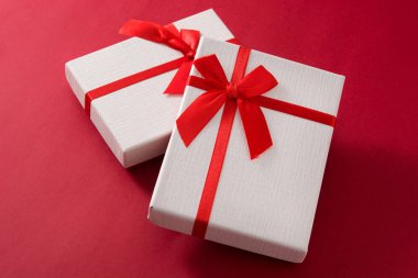 Kırmızı arkaplanda çeşitli beyaz hediye kutuları.