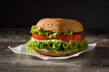 Sebzeli sandviç, domates, marul ve ahşap masada mozzarella peyniri..