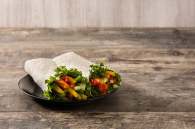 Sebzeli tortilla ambalajı ahşap masada. Boşluğu kopyala