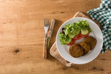 Seitan ve sebzeler ahşap masanın üstünde. Üst görünüm kopyalama alanı. Sahte et.