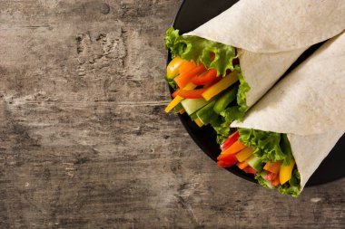 Sebzeli tortilla ambalajı ahşap masada. Üst Manzara. Boşluğu kopyala