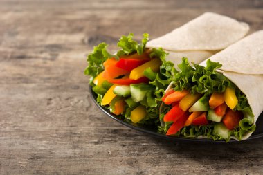 Sebzeli tortilla ambalajı ahşap masada. Boşluğu kopyala