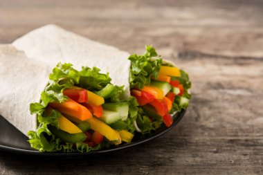 Sebzeli tortilla ambalajı ahşap masada. Boşluğu kopyala