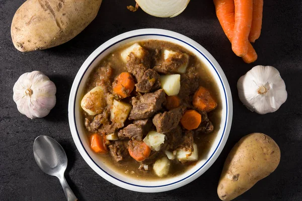 Iers Rundvlees Stoofpot Met Wortels Aardappelen Zwarte Achtergrond Bovenaanzicht — Stockfoto