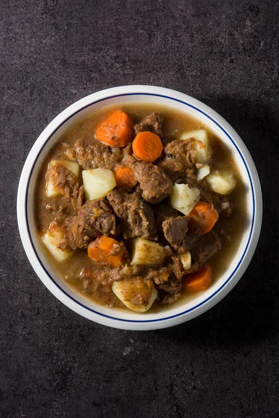 Ierse Runderstoofpot Met Wortels Aardappelen Zwarte Achtergrond Bovenaanzicht — Stockfoto