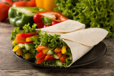 Sebzeli tortilla ahşap masaya sarılmış.