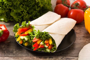 Sebzeli tortilla paketleri ve malzemeler ahşap masada.. 