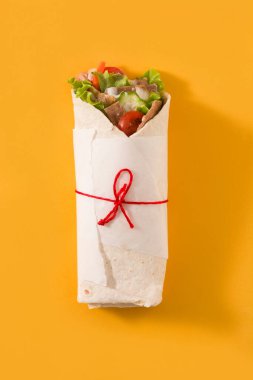 Sarı arka planda izole edilmiş kebap ya da shawarma sandviçi