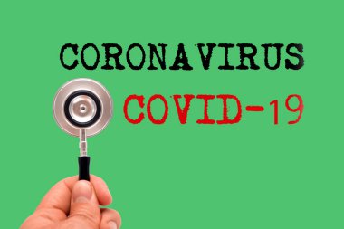 Yeşil arka planda Coronavirus ve Covid-19 kelimeleriyle steteskop.