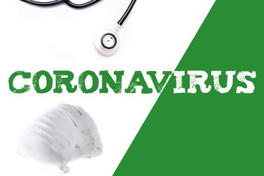 Beyaz ve yeşil arka planda Coronavirus kelimesi, steteskop ve yüz maskesi