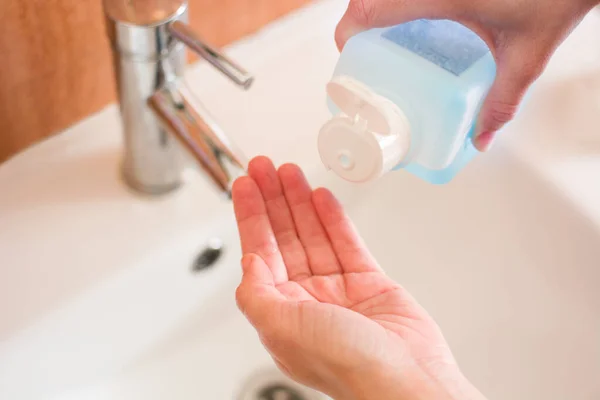 妇女的手在浴室里撒布消毒剂凝胶 — 图库照片