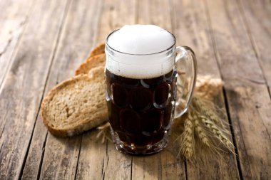 Geleneksel kvass bira kupası ve ahşap masada çavdar ekmeği.