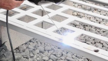 Dışarıdaki demir kapıyı kaynaklayan adam.