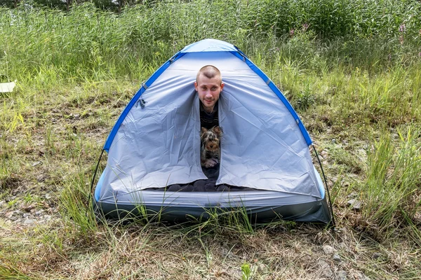 Muž se psem vyhlédl naše postavení stanu v lese — Stock fotografie