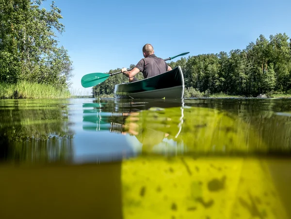 Un hombre nada en un kayak en el lago en el día de verano — Foto de Stock