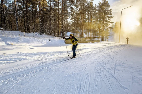 Un esquiador corre por las pistas esquiando en el bosque —  Fotos de Stock