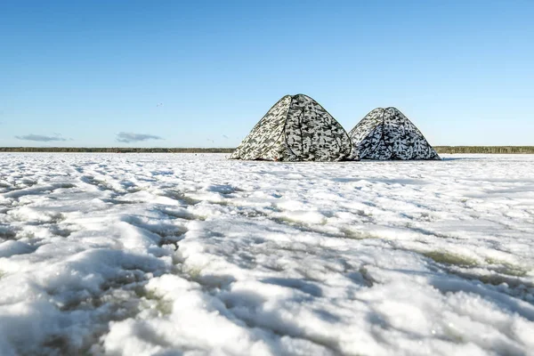 Tende pescatori in piedi sul lago ghiacciato nella giornata invernale — Foto Stock