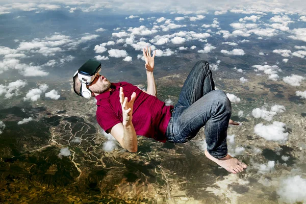 De man in virtuele werkelijkheid glazen vliegen op sky — Stockfoto