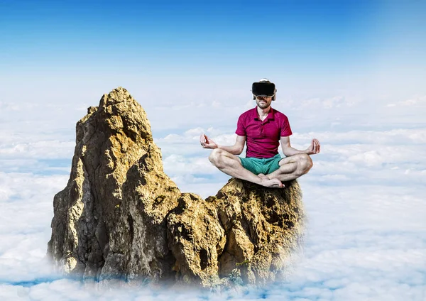De man in virtuele werkelijkheid bril zitten in de lotuspositie — Stockfoto