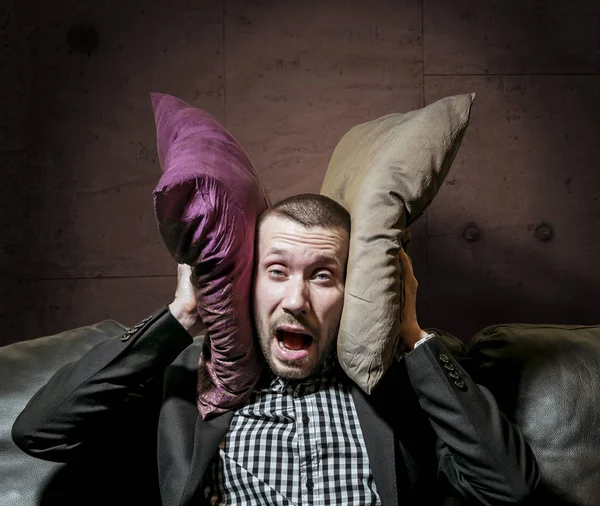 Człowiek w garniturze, obejmujące jej uszy z poduszkami i krzyczeć z powrotem — Zdjęcie stockowe