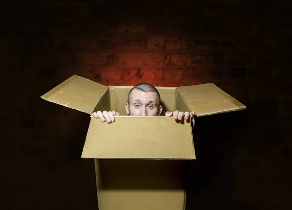 Um homem olha para fora da caixa apertado — Fotografia de Stock