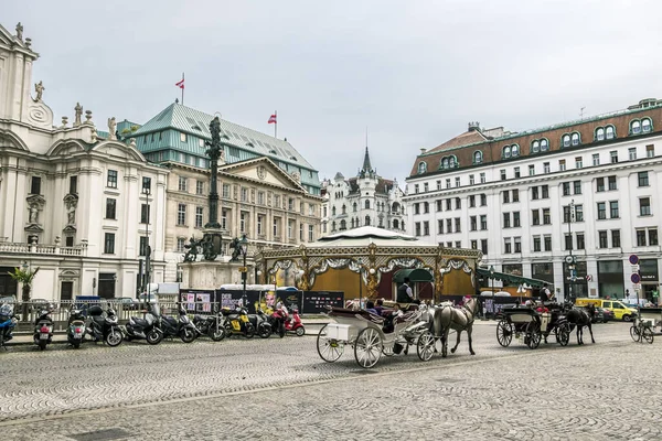 Los carruajes tirados por caballos llevan a los turistas por el centro histórico i — Foto de Stock