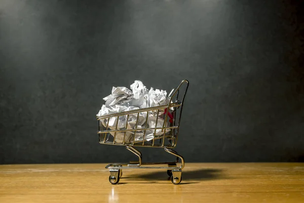 A pile of crumpled paper in a miniature grocery cart — ストック写真