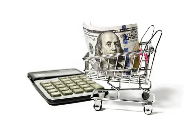 Calculator and dollar bills in miniature grocery cart — Stock Photo, Image