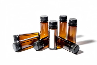 Kapaklı birkaç tıbbi test tüpü var ve beyaz arka planda yatıyorlar.