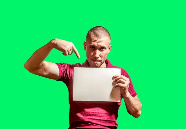 Mężczyzna Wskazuje Biały Prześcieradło Dłoni Zielonym Tle — Zdjęcie stockowe
