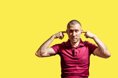 Adam parmaklarıyla kulaklarını sarı arka plana koydu.