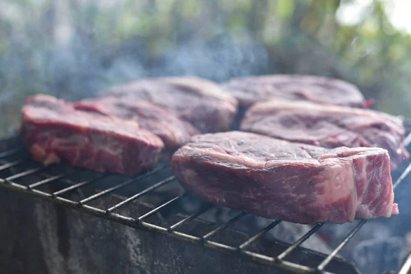 Chuck rotola bistecca. rotolo di mandrino alla griglia Cucinare la carne da un cuoco professionista in un falò all'aria aperta . — Foto Stock