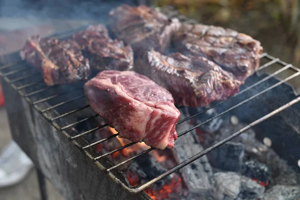 Chuck rotola bistecca. rotolo di mandrino alla griglia Cucinare la carne da un cuoco professionista in un falò all'aria aperta . — Foto Stock