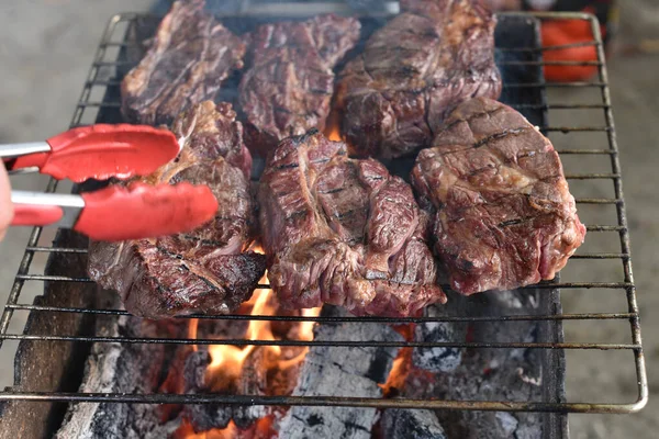 Bife Chuck Roll. rolo de pato grelhado Cozinhar carne por um cozinheiro profissional em uma fogueira ao ar livre . — Fotografia de Stock