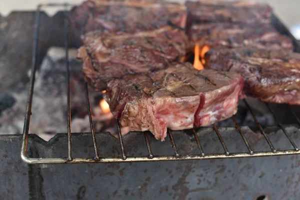 Chuck rollo de filete. rollo de pato a la parrilla Cocinar la carne de un cocinero profesional en una hoguera al aire libre . — Foto de Stock