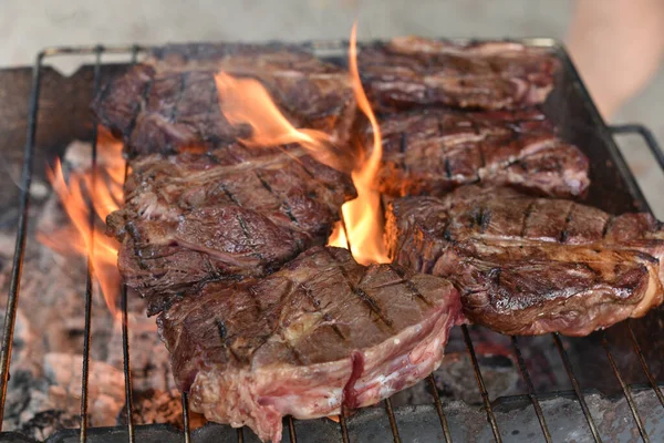 Chuck rotola bistecca. rotolo di mandrino alla griglia Cucinare la carne da un cuoco professionista in un falò all'aria aperta . — Foto Stock