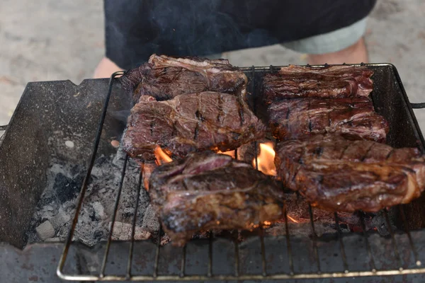 Chuck rotola bistecca. rotolo di mandrino alla griglia Cucinare la carne da un cuoco professionista in un falò all'aria aperta . — Foto Stock