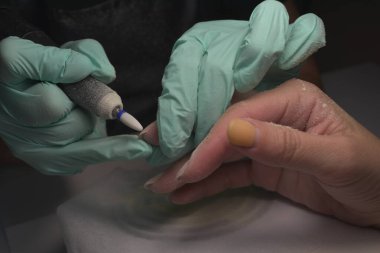 Kadın elleri güzellik salonunda manikür yaptırıyor. Tırnak törpüleme. Yaklaş, seçici odaklanma.