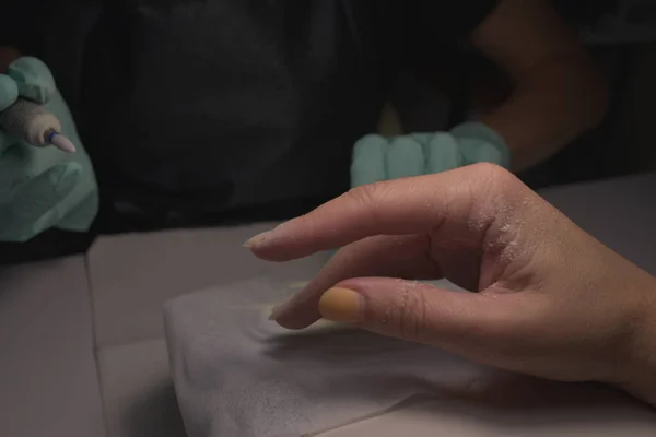 Vrouw handen ontvangen een manicure in schoonheidssalon. Nagelvijl. Close-up, selectieve focus. — Stockfoto
