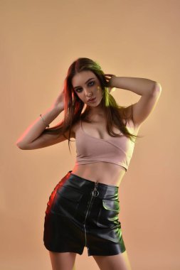 Dolgun doğal rujlu muhteşem bir esmer. Stüdyoda renkli filtrelerle çekilmiş bir model. Moda, güzellik, ışıltı.