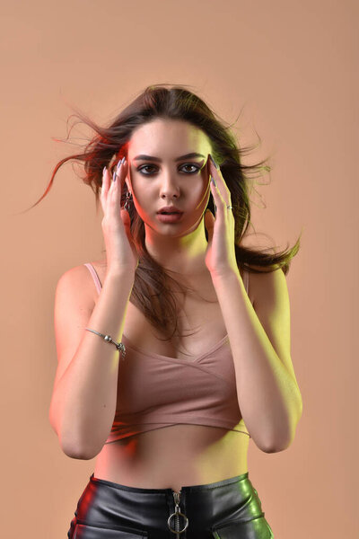 Gorgeous brunette with plump natural lips.Model shot in the studio with color filters. Fashion, beauty, glow.