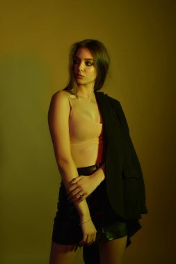 Dolgun doğal rujlu muhteşem bir esmer. Stüdyoda renkli filtrelerle çekilmiş bir model. Moda, güzellik, ışıltı.