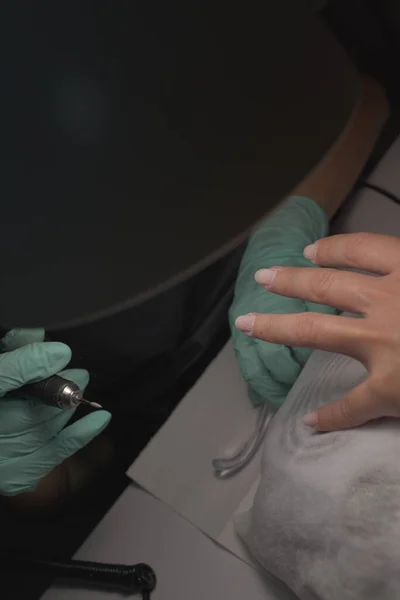 Vrouw handen ontvangen een manicure in schoonheidssalon. Nagelvijl. Close-up, selectieve focus. — Stockfoto