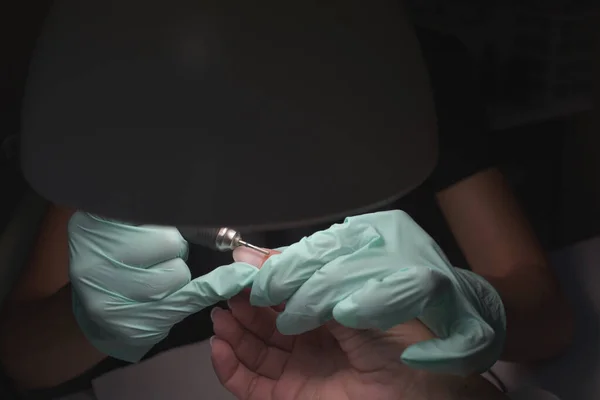 Vrouw handen ontvangen een manicure in schoonheidssalon. Nagelvijl. Close-up, selectieve focus. — Stockfoto