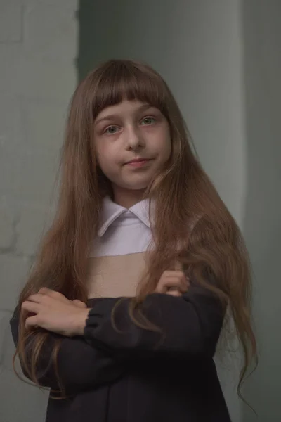 Niña colegiala de pie. Niño de 9 años colegiala en un vestido de escuela con pelo castaño . — Foto de Stock