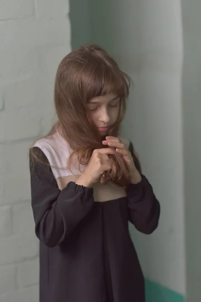 Fetiţa stă la picioare. Copil de 9 ani scolarita intr-o rochie scolara cu par castaniu . — Fotografie, imagine de stoc