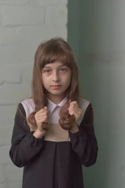 Petite écolière debout. Enfant 9 ans écolière dans une robe d'école aux cheveux bruns . — Photo