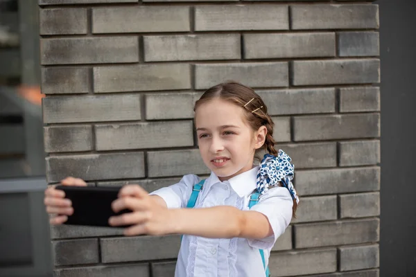 Χαμογελώντας beatiful preteen κορίτσι λαμβάνοντας μια selfie έξω. Παιδί παίρνει μια αυτο-πορτρέτο με το κινητό τηλέφωνο. τεχνολογία — Φωτογραφία Αρχείου