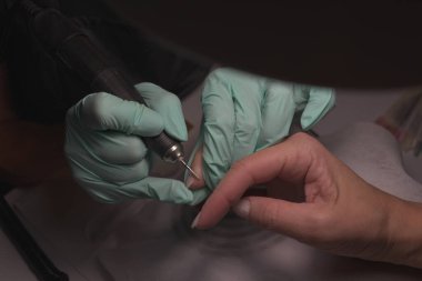 Kadın elleri güzellik salonunda manikür yaptırıyor. Tırnak törpüleme. Yaklaş, seçici odaklanma.